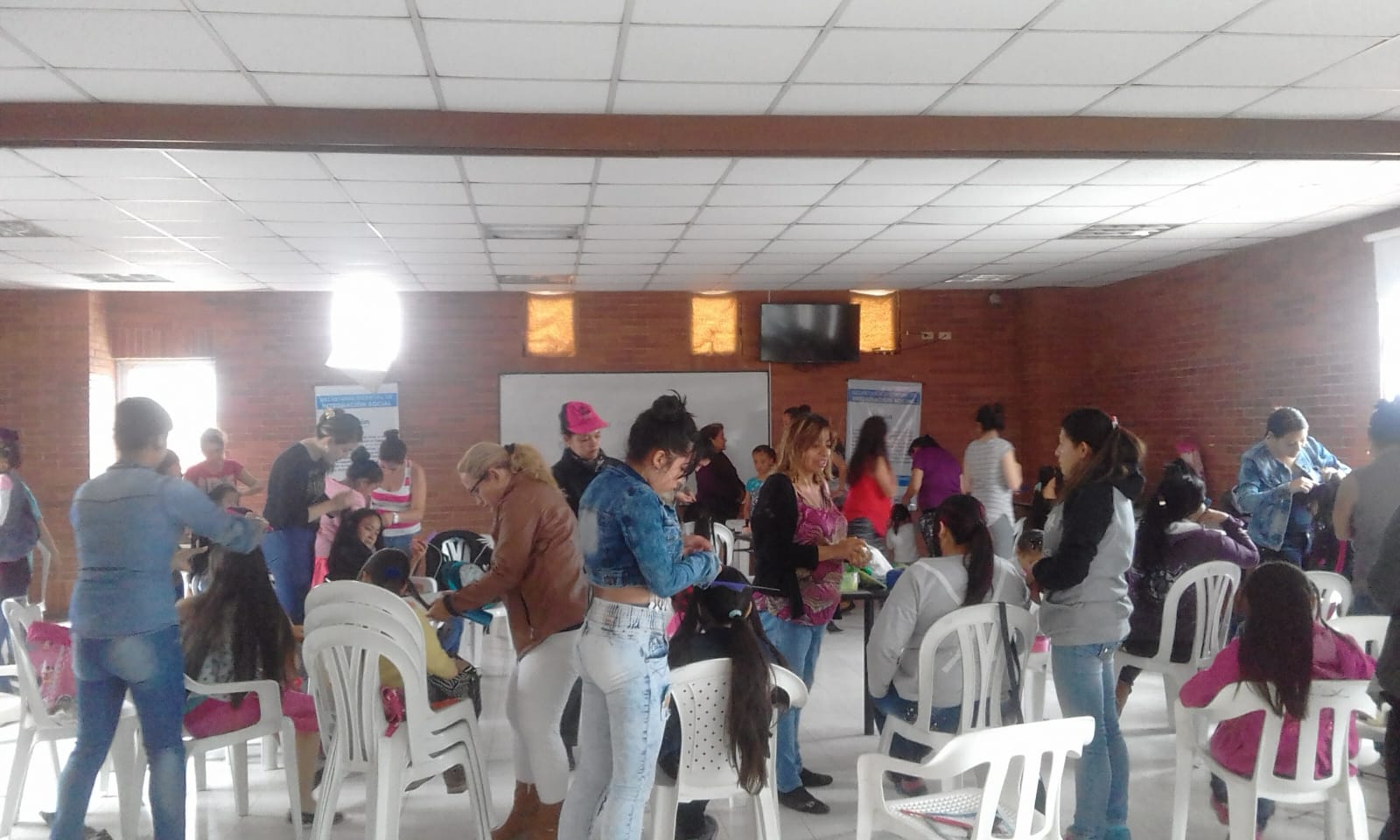 Grupo de mujeres practicando peinados en salón comunitario durante el curso de belleza, Fundación Rosas del Carmelo, Bogotá
