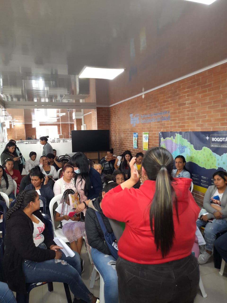 Voluntaria peinando a una niña en patio de casa durante jornada de belleza, Fundación Rosas del Carmelo, Bogotá