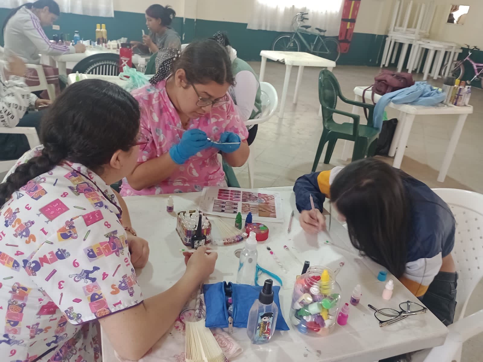 Estudiante practicando manicura sobre mesa con herramientas de uñas, curso de belleza, Fundación Rosas del Carmelo