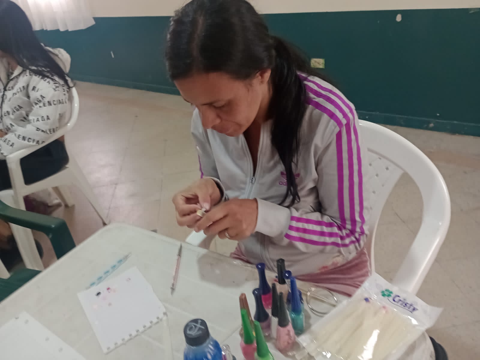 Estudiante puliendo uña postiza como práctica del curso de manicura, Fundación Rosas del Carmelo