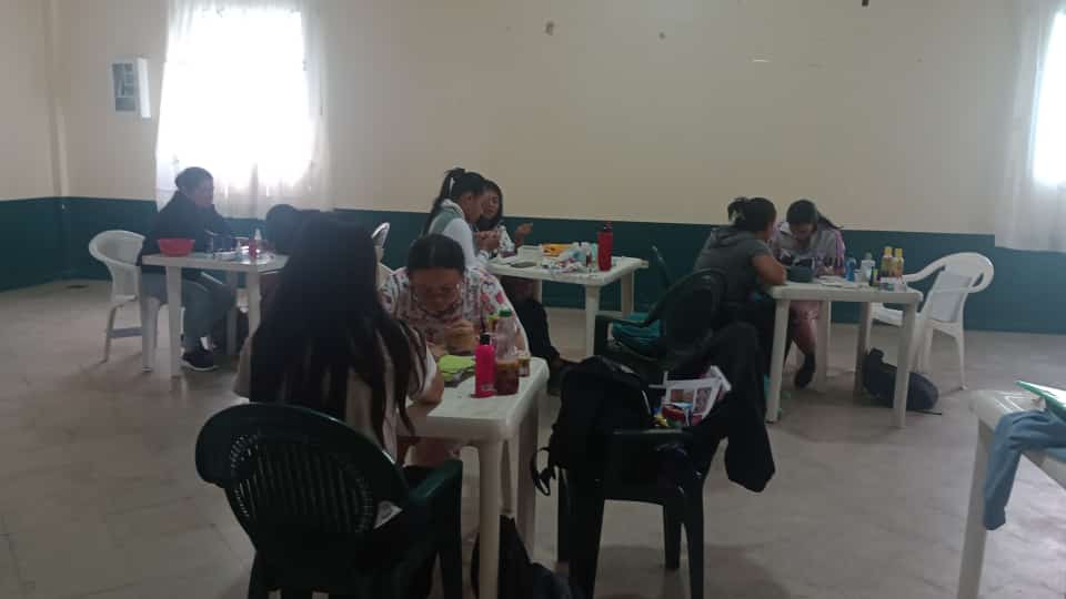 Grupo de estudiantes en salón practicando manicura sobre varias mesas, curso de belleza, Fundación Rosas del Carmelo