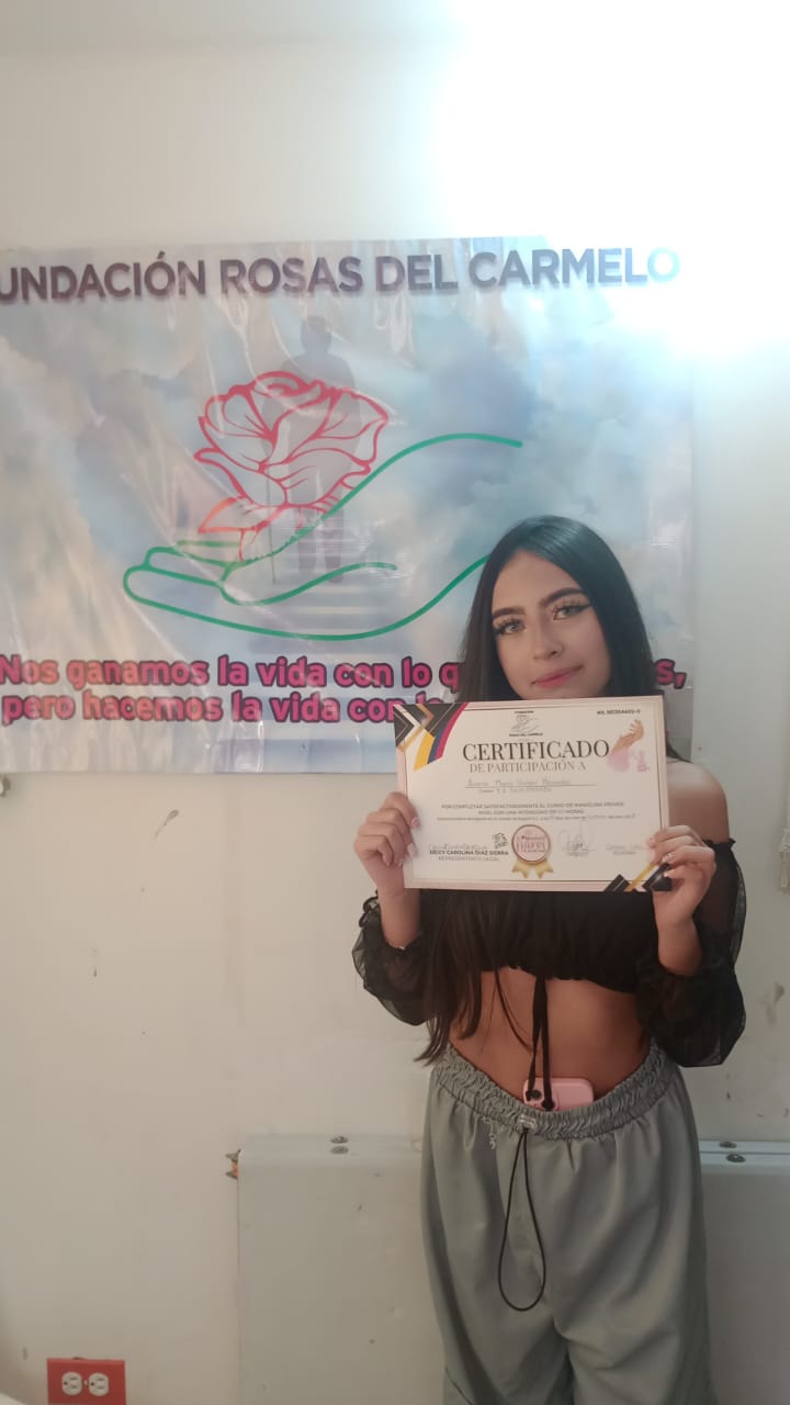 Estudiante practicando manicura junto a otra compañera concentrada en su trabajo, curso de belleza, Fundación Rosas del Carmelo