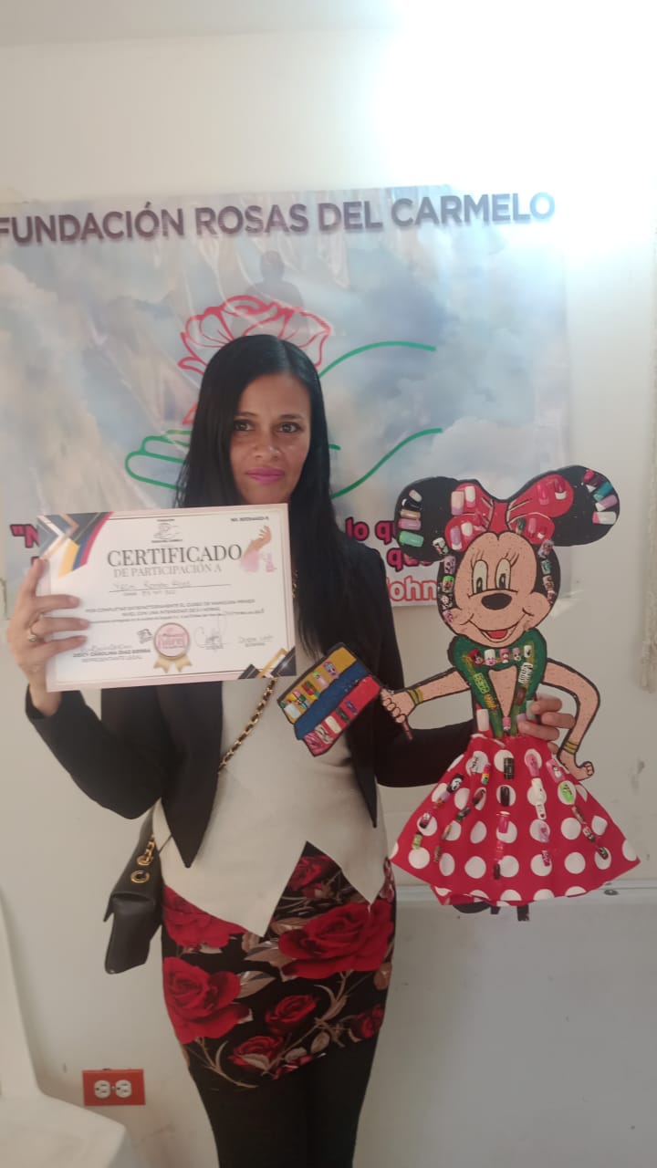 Graduada del curso de manicura sosteniendo su certificado de participación, Fundación Rosas del Carmelo