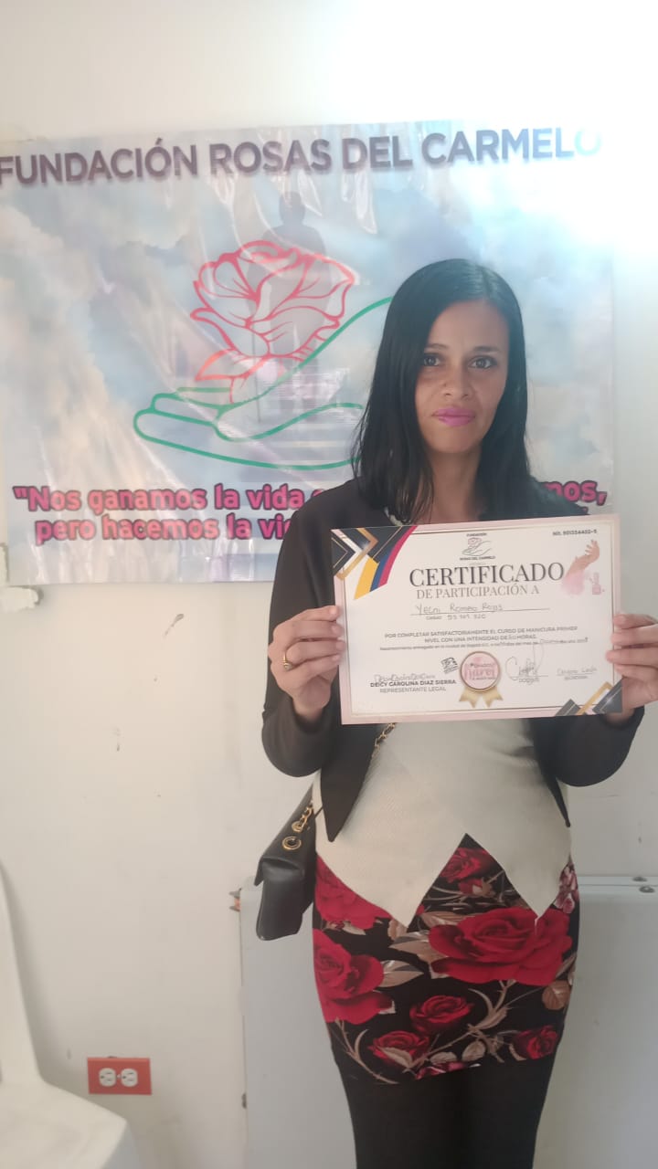 Graduada del curso de manicura sosteniendo su certificado de participación, Fundación Rosas del Carmelo