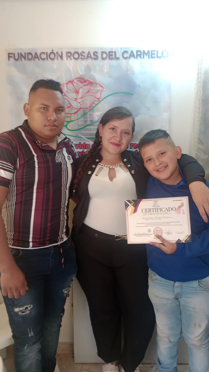 Graduada del curso de manicura sosteniendo su certificado de participación, Fundación Rosas del Carmelo