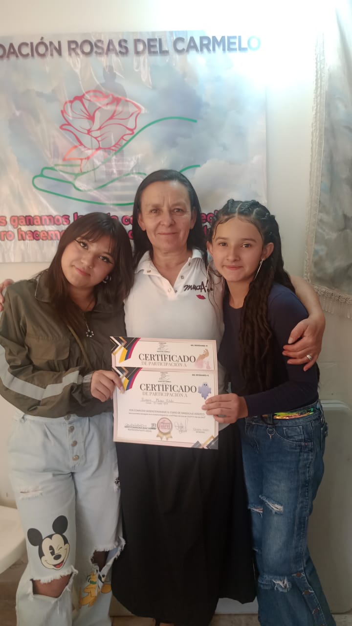 Graduada del curso de manicura sosteniendo su certificado de participación, Fundación Rosas del Carmelo