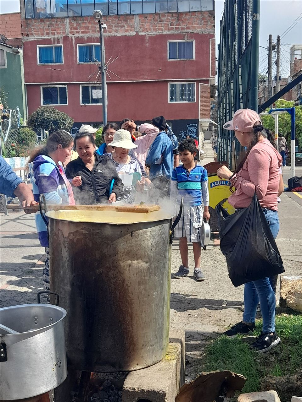 Voluntarios reunidos alrededor de una olla humeante de sancocho, Fundación Rosas del Carmelo, Bogotá