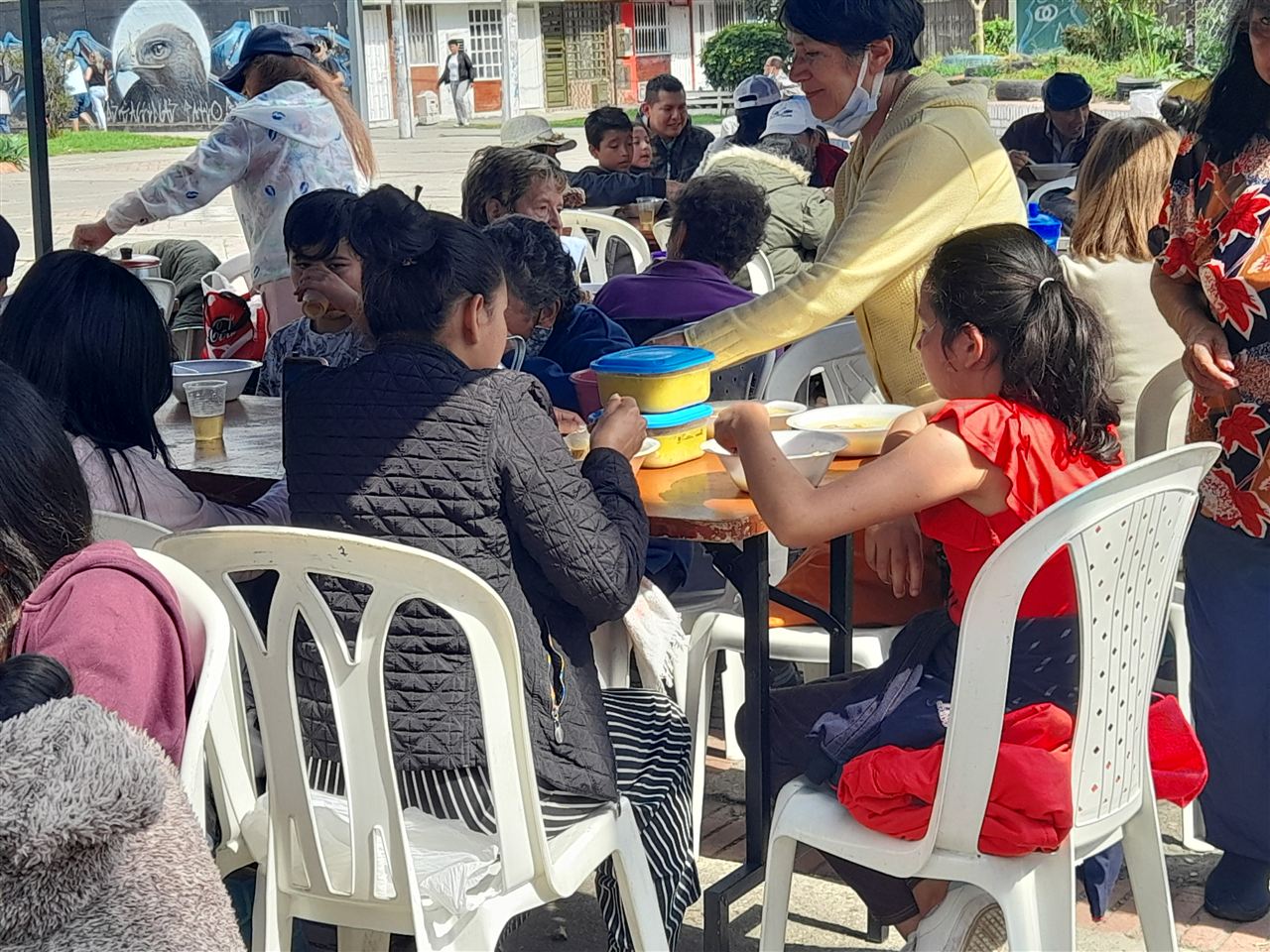 Niños compartiendo mesa y comiendo sancocho en jornada comunitaria, Fundación Rosas del Carmelo, Bogotá