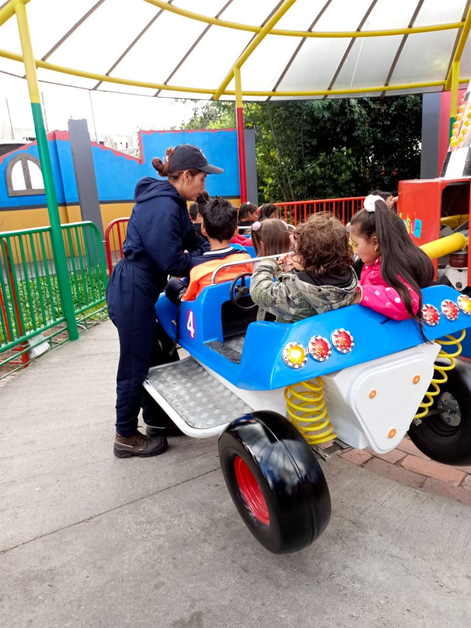 Niños en juego infantil de carro durante las Vacaciones Recreativas, Fundación Rosas del Carmelo, Bogotá