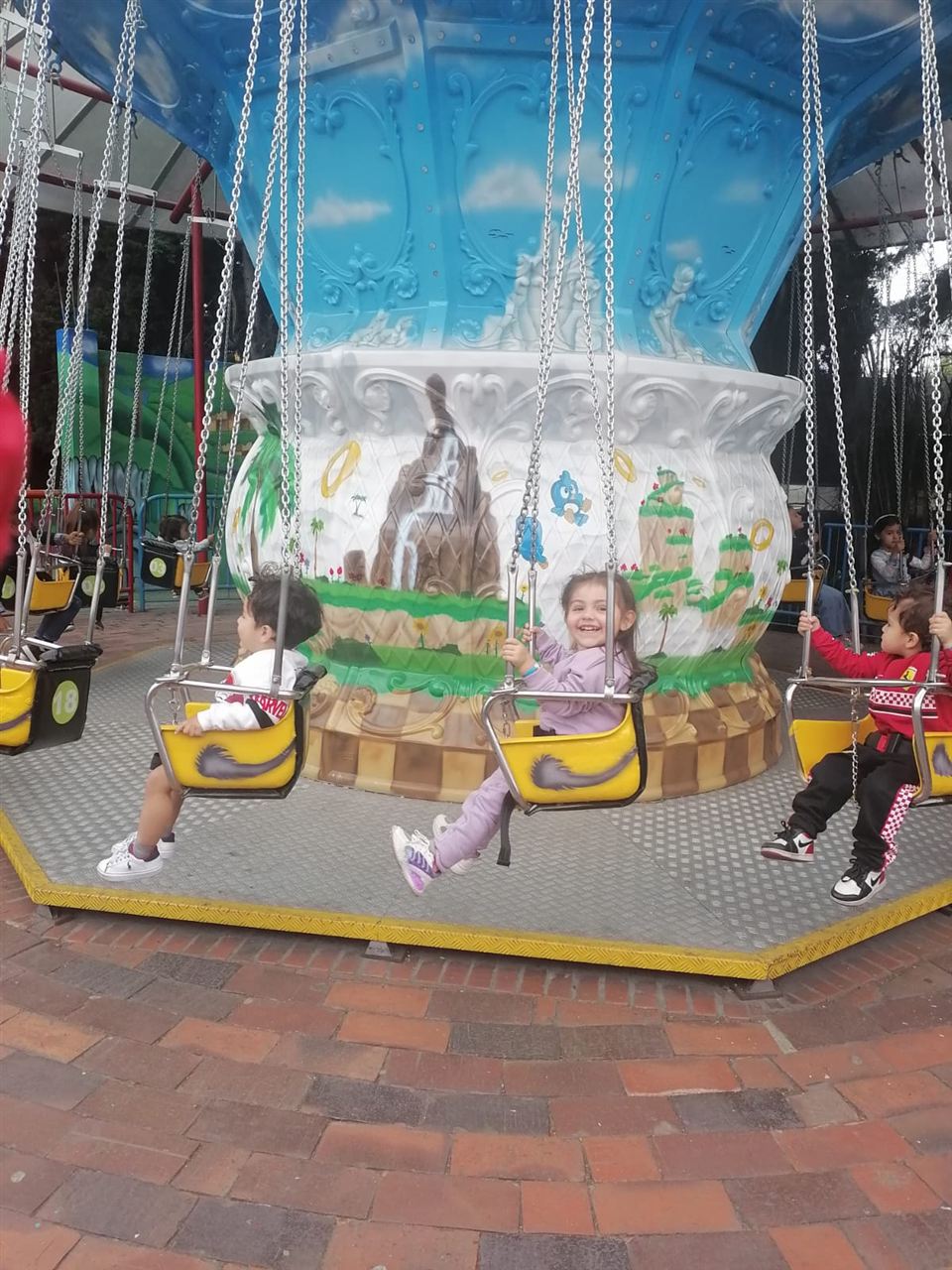 Niños en el juego de columpios voladores durante las Vacaciones Recreativas, Fundación Rosas del Carmelo, Bogotá