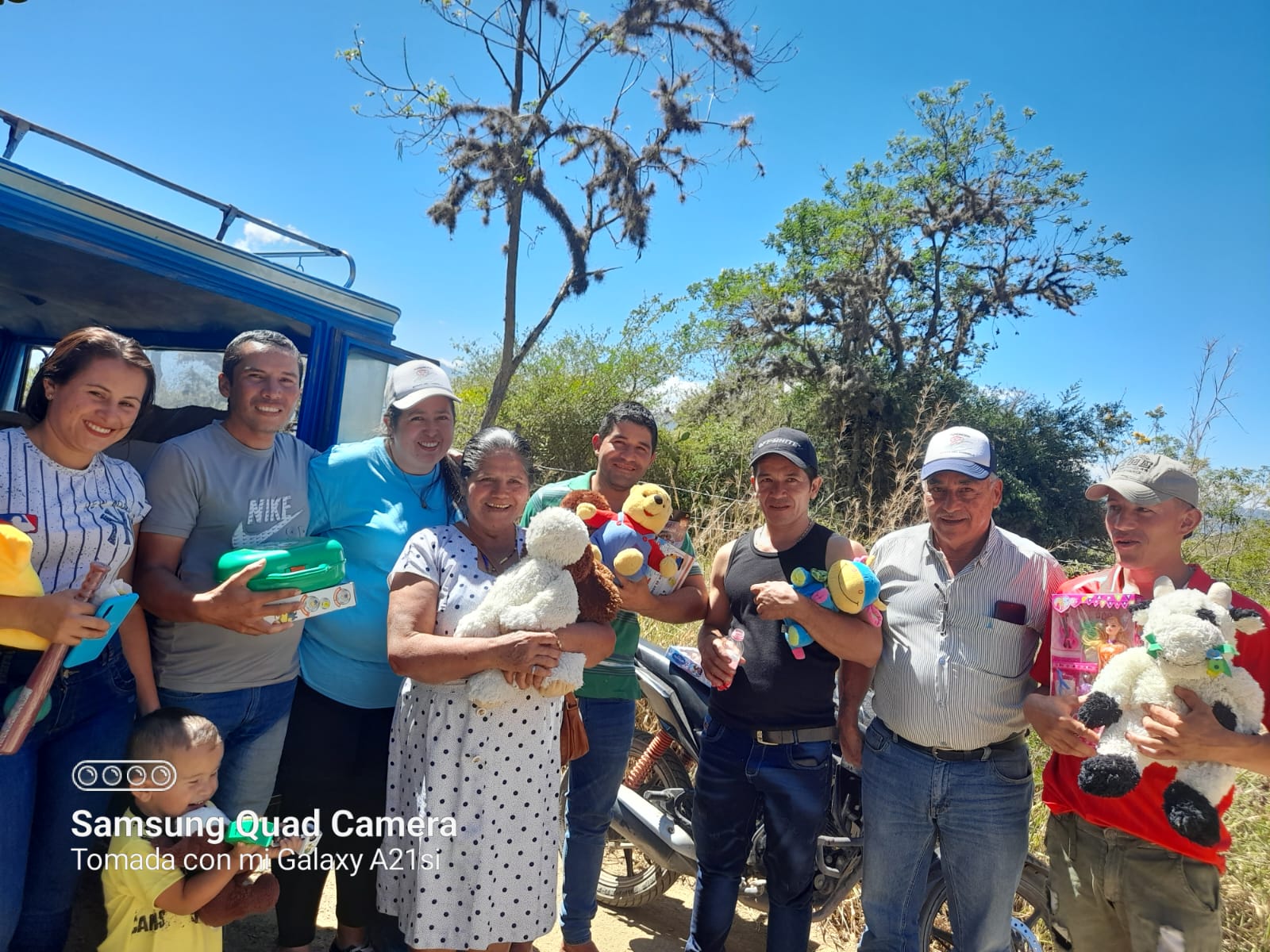Voluntarios y familia entregando juguetes de peluche en zona rural, Fundación Rosas del Carmelo