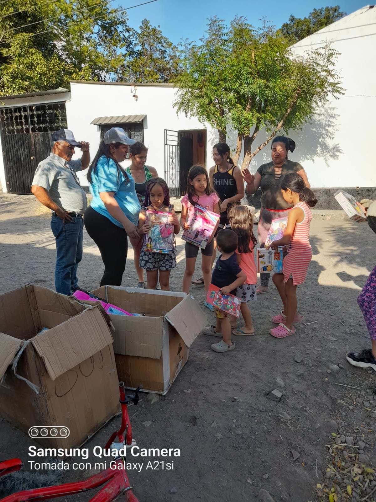 Niños recibiendo regalos y libros para colorear en un barrio de Bogotá, Fundación Rosas del Carmelo