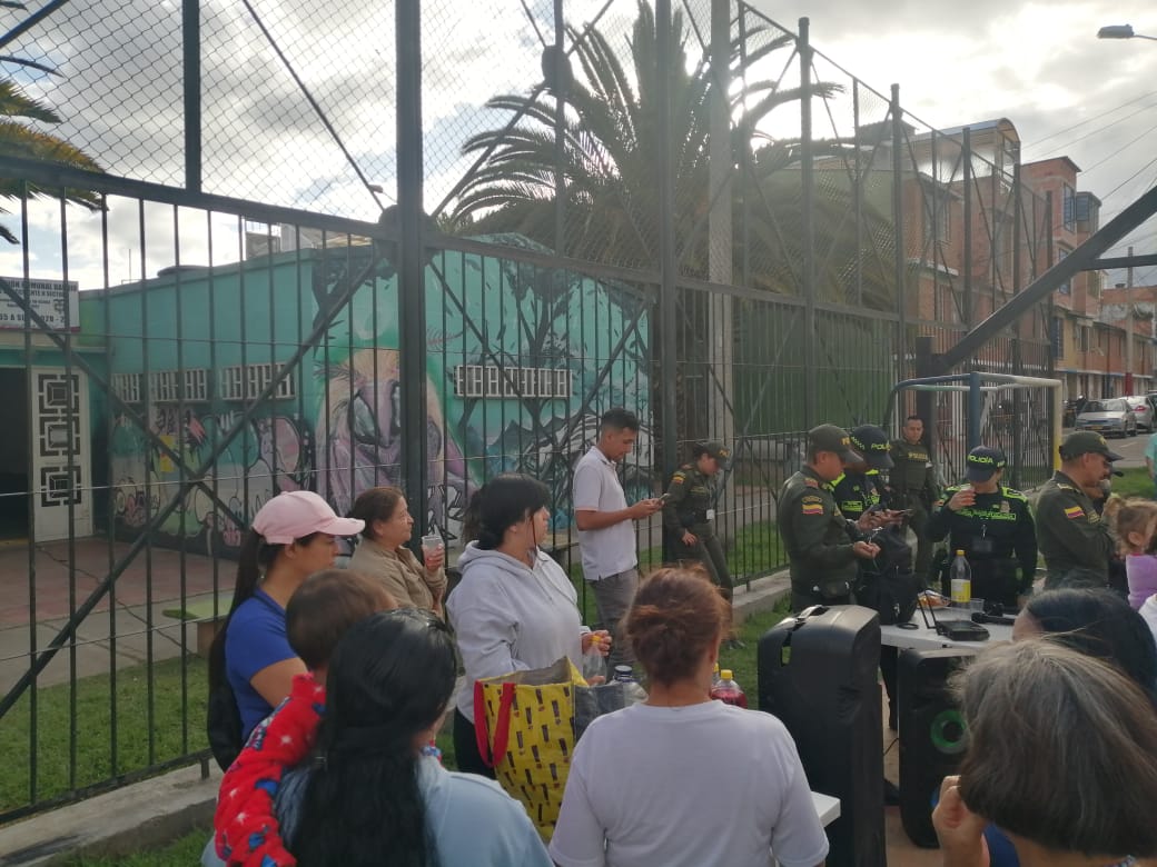 Reunión comunitaria junto a un polideportivo con mural, Fundación Rosas del Carmelo, Bogotá