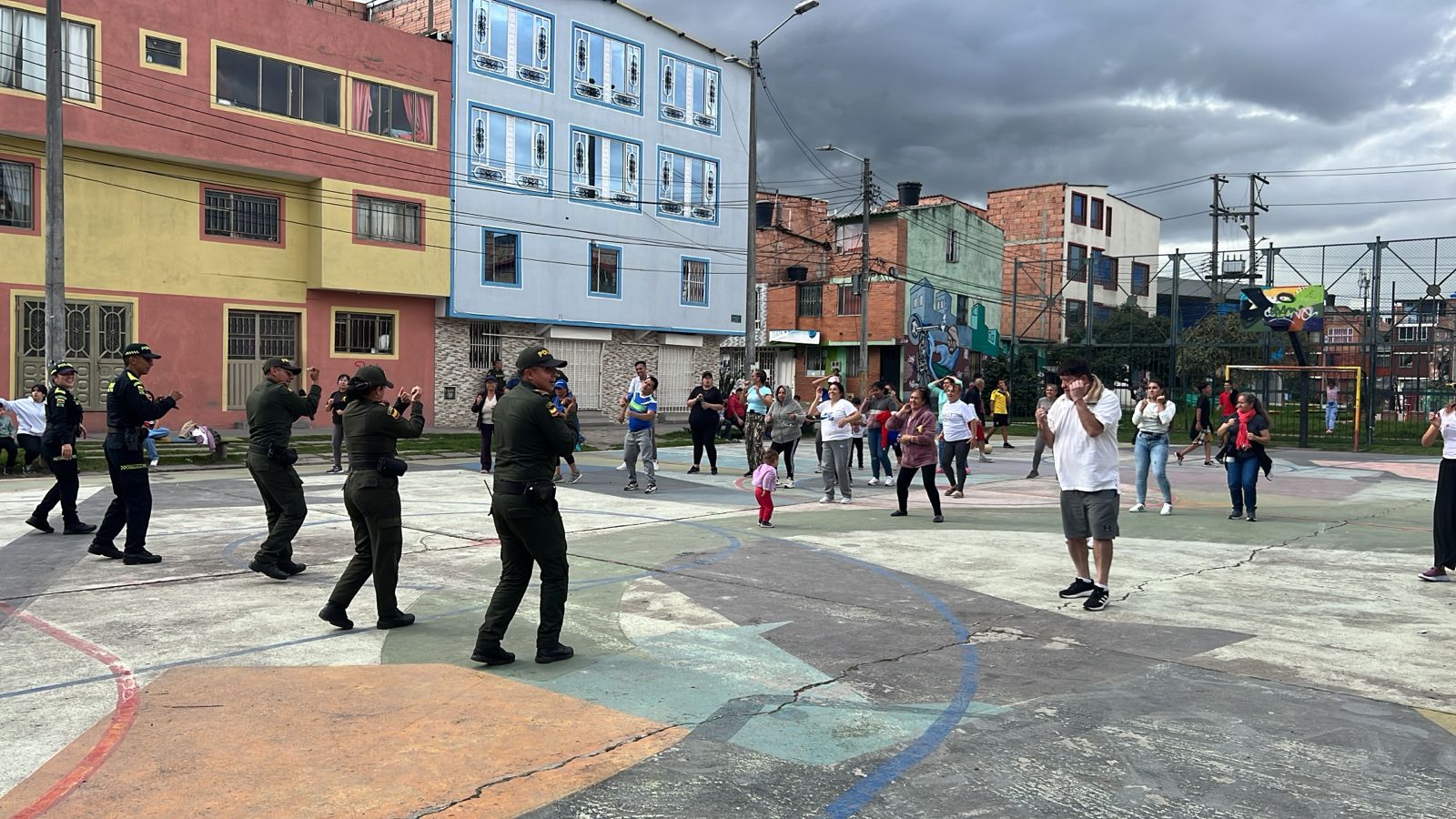 Policías bailando con la comunidad en cancha del barrio, Fundación Rosas del Carmelo, Bogotá