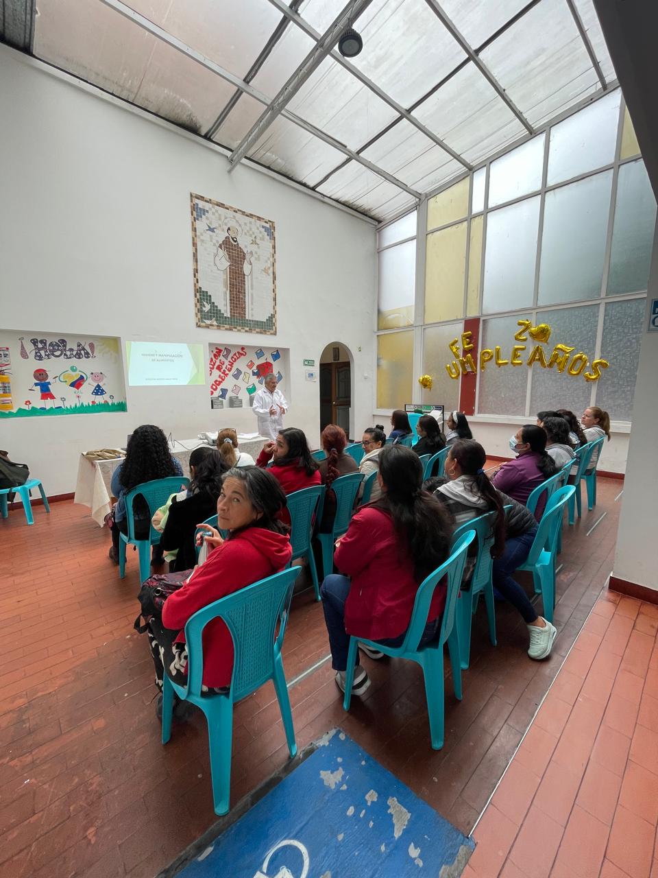 Charla educativa sobre manejo de alimentos con adultos en salón comunitario, Fundación Rosas del Carmelo, Bogotá